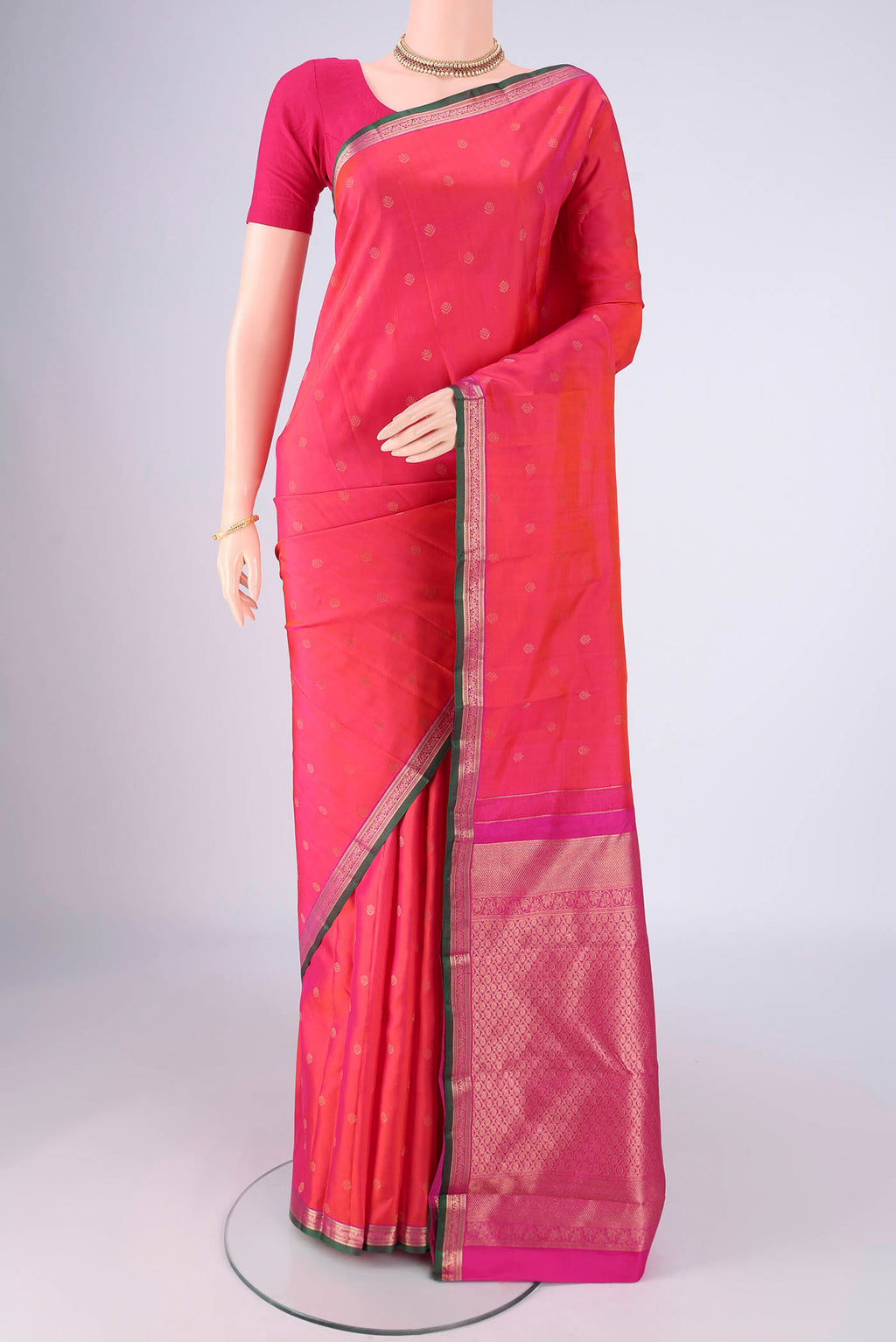 Coral Kanchipuram Silk Saree with Zari Butta on the body and Zari Border.  displayed on a mannequin
