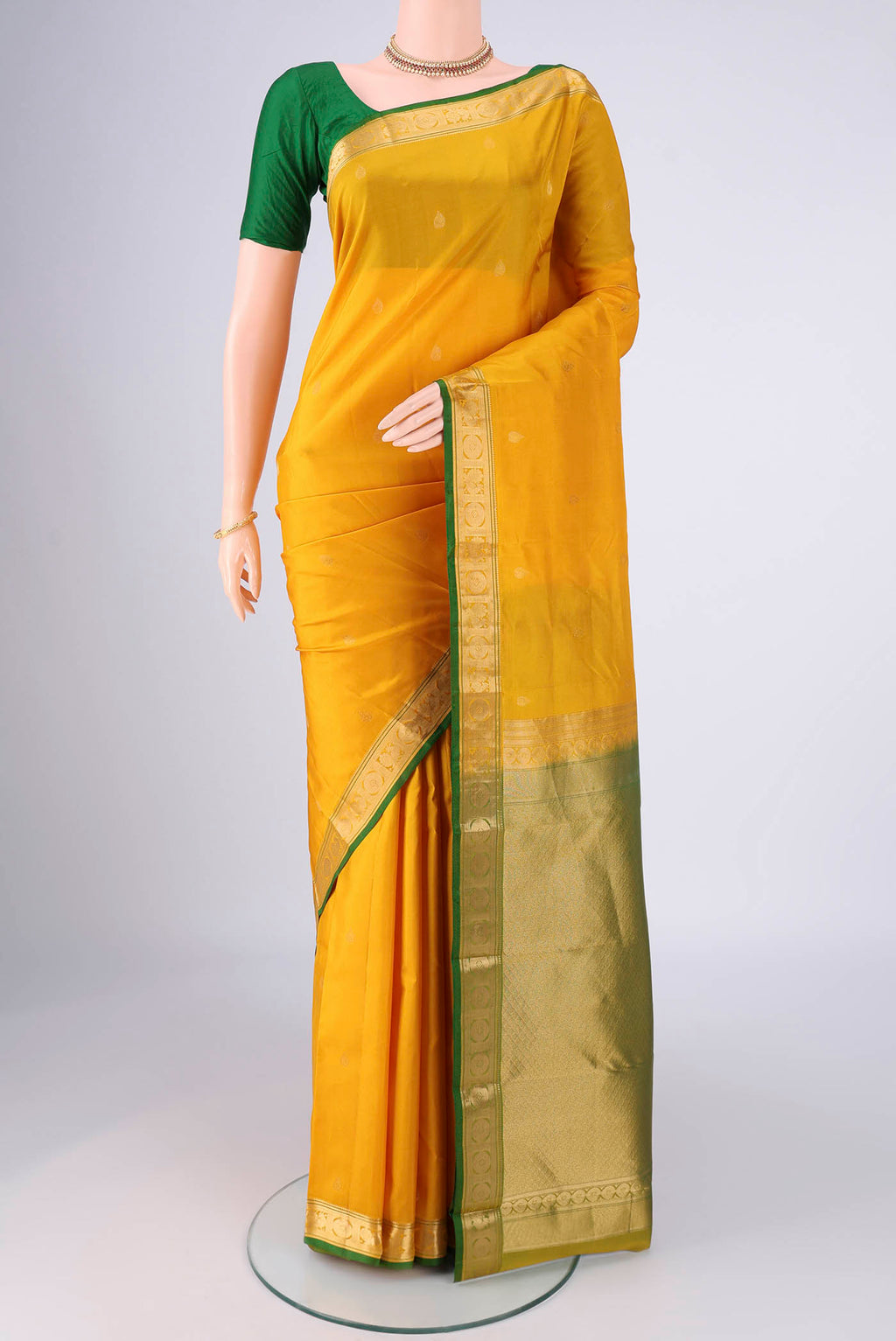 Yellow Kanchipuram Silk Saree with Zari Butta on the body and Zari Border.  displayed on a mannequin