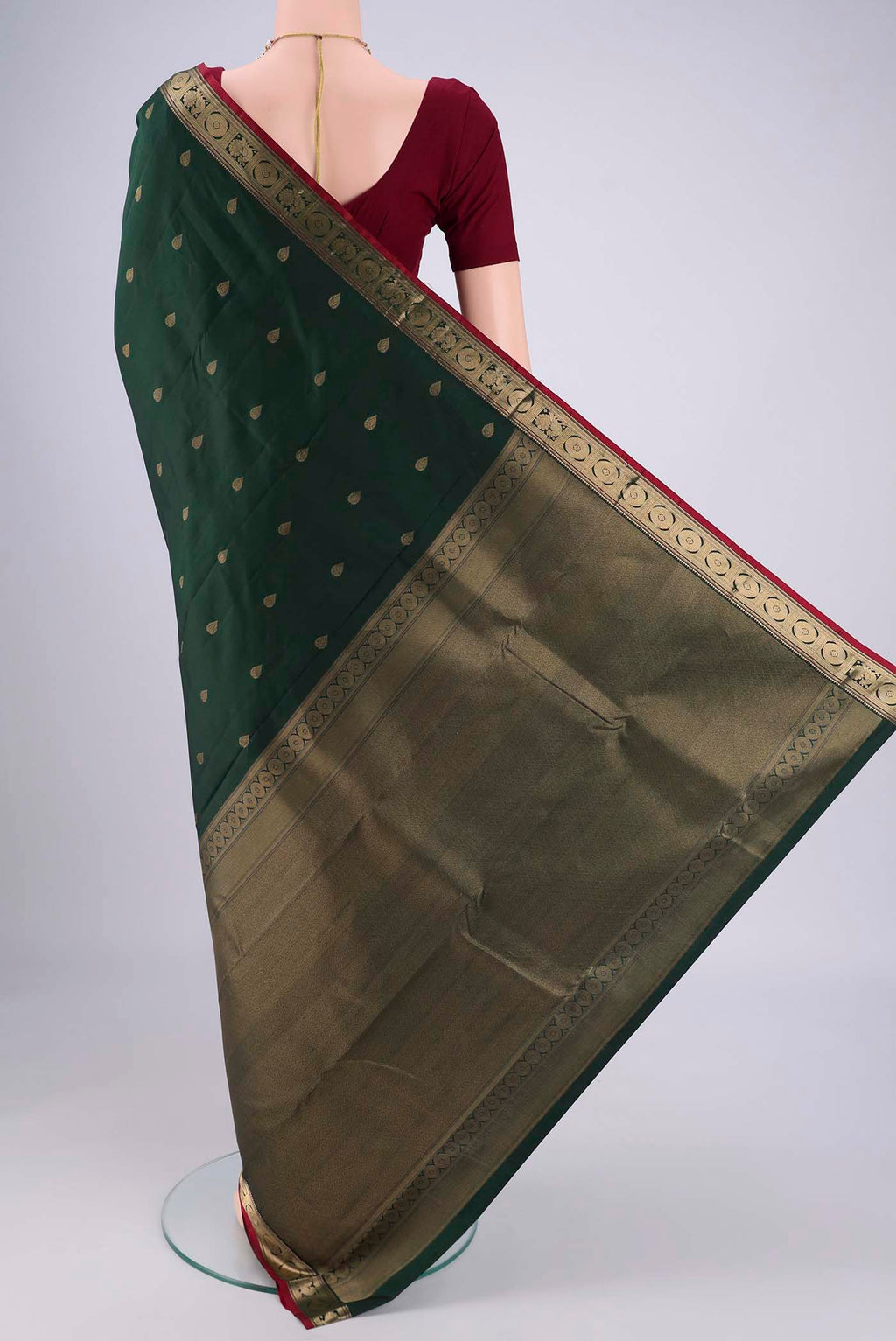 Flat view of Bottle Green Kanchipuram Silk Saree with Zari Butta on the body and Zari Border. 