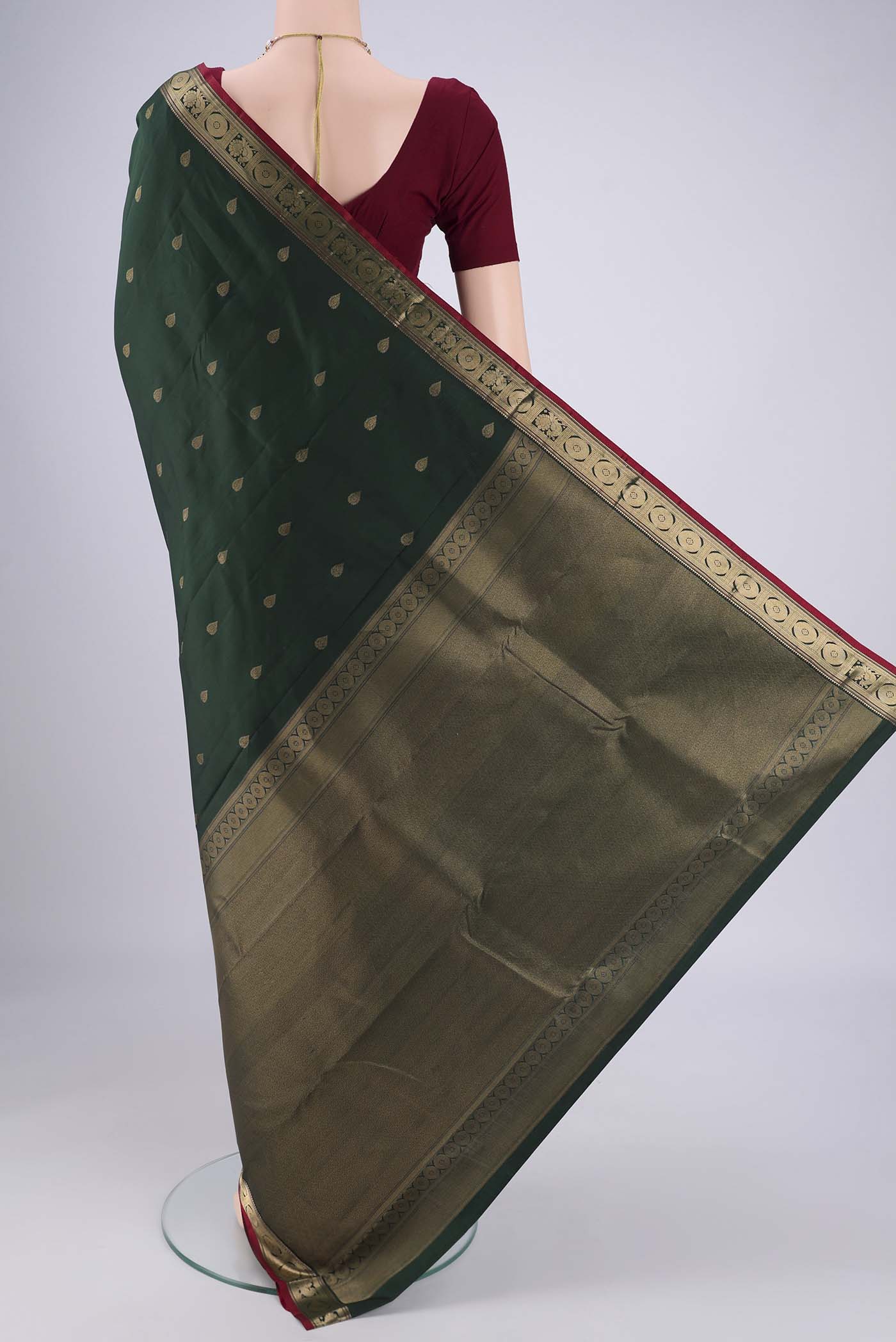 Flat view of Bottle Green Kanchipuram Silk Saree with Zari Butta on the body and Zari Border. 