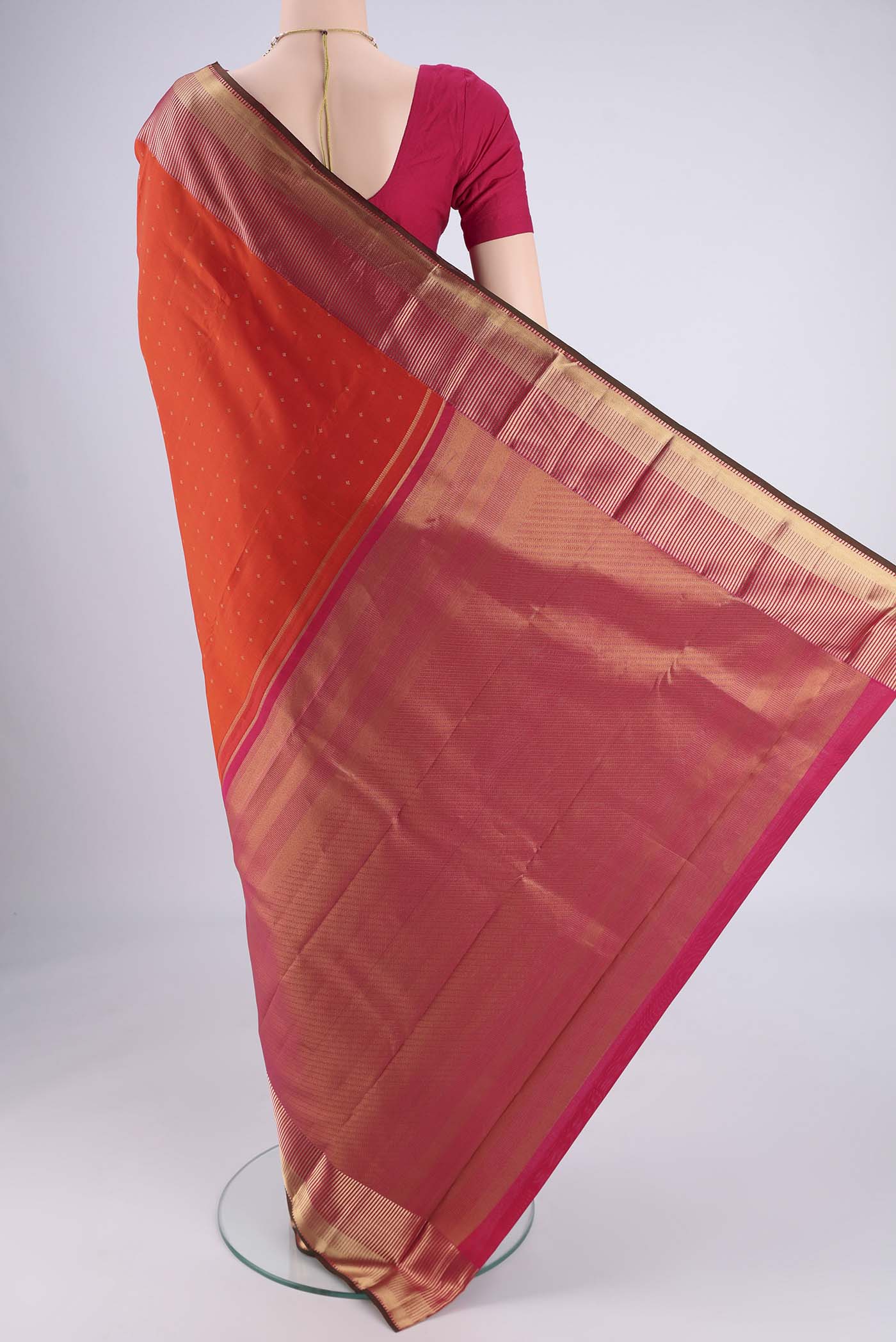 Flat view of Orange Kanchipuram Silk Saree with Zari Butta on the body and Zari Border. 