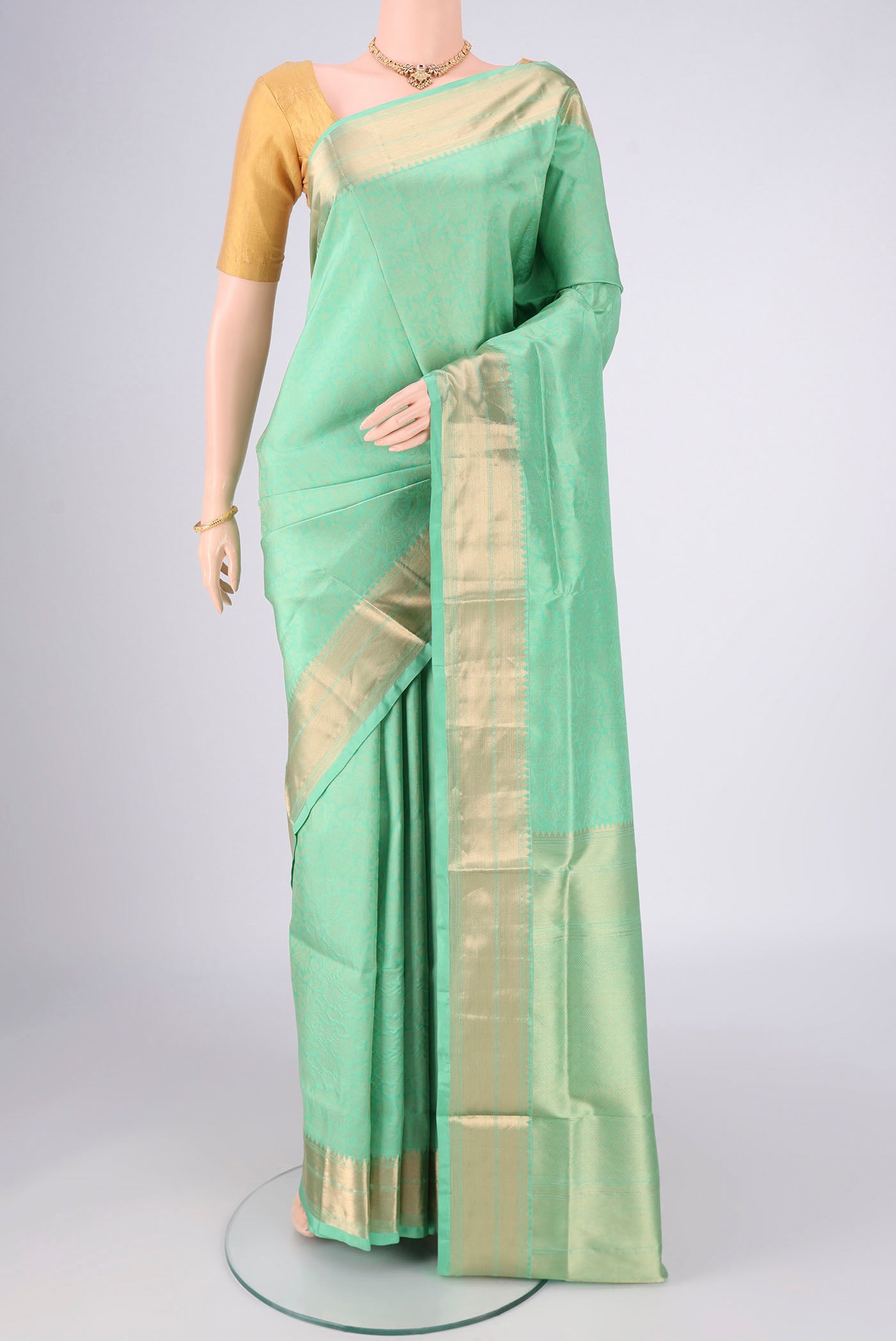 Mint Green Soft Silk Saree with Zari Brocade on the body and Zari Border.  displayed on a mannequin