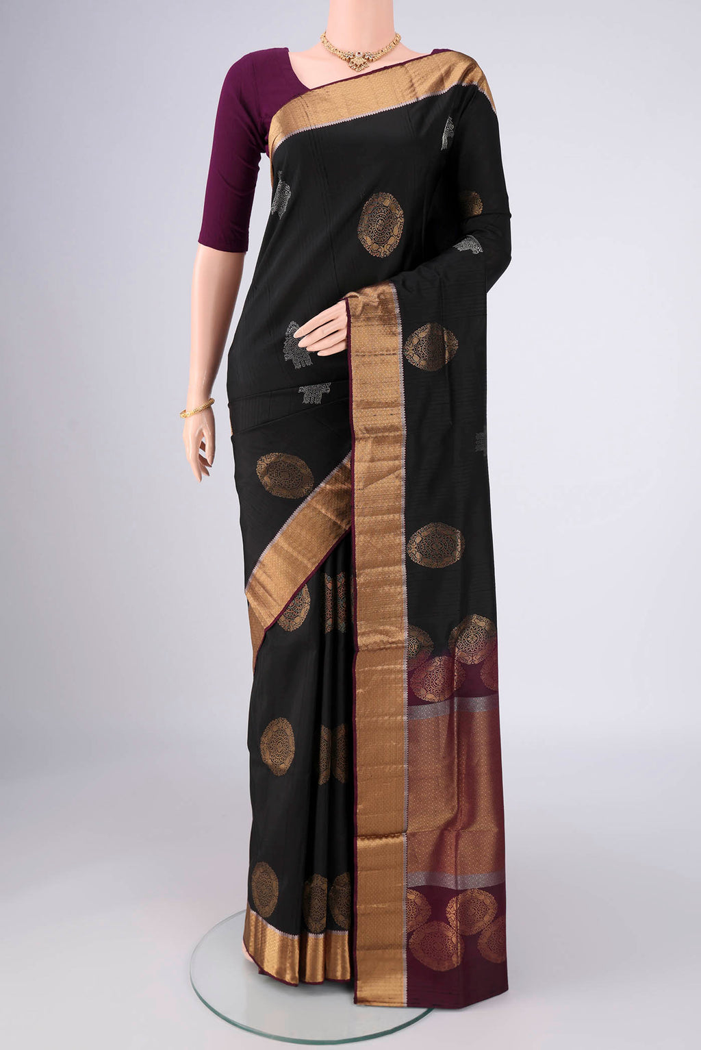 Black Soft Silk Saree with Zari Butta on the body and Zari Border.  displayed on a mannequin