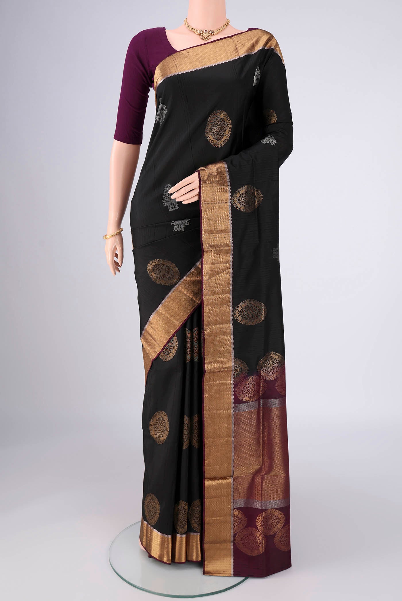 Black Soft Silk Saree with Zari Butta on the body and Zari Border.  displayed on a mannequin