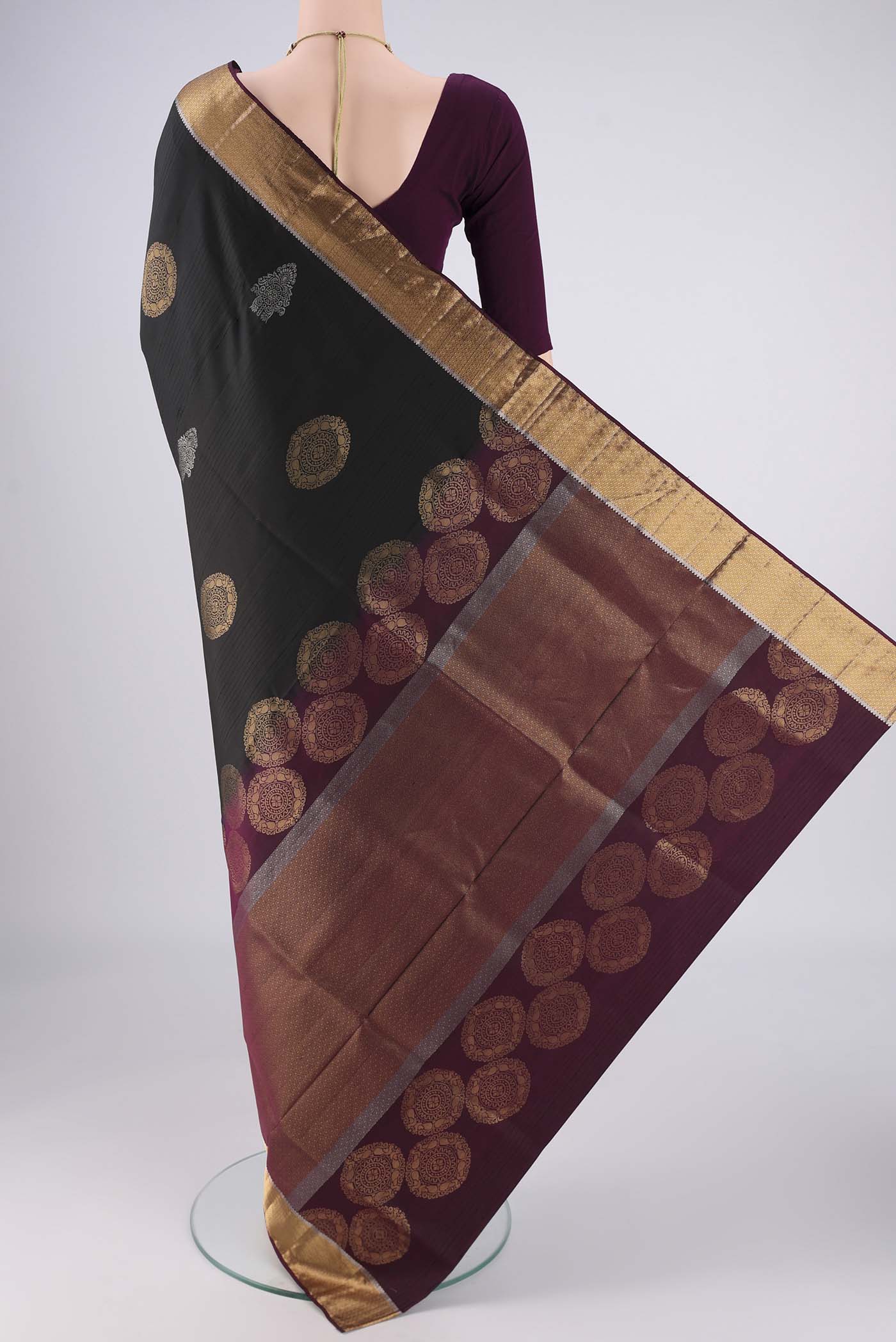 Flat view of Black Soft Silk Saree with Zari Butta on the body and Zari Border. 