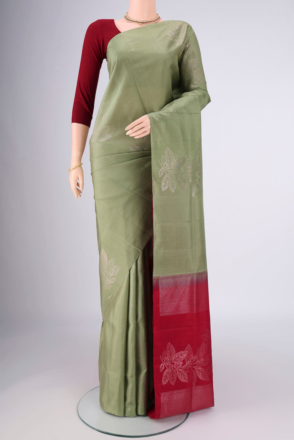 Sage Green Soft Silk Saree with Zari Butta on the body and Without Border.  displayed on a mannequin