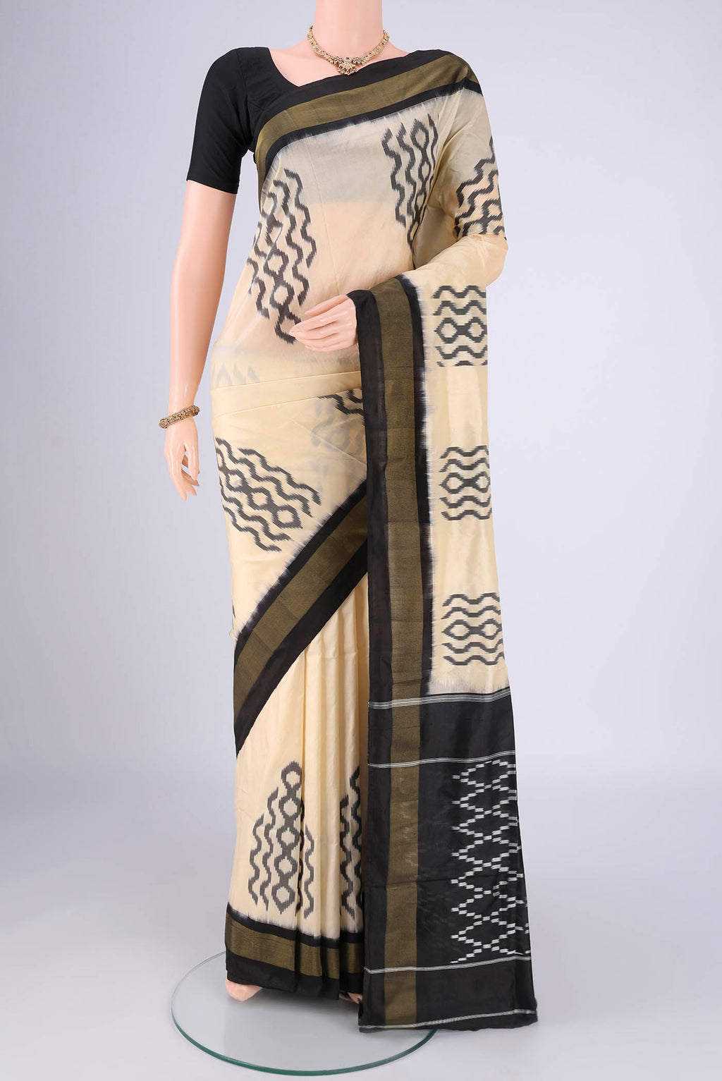Cream Pochampally Silk Saree with Ikat design on the body and Plain Border.  displayed on a mannequin