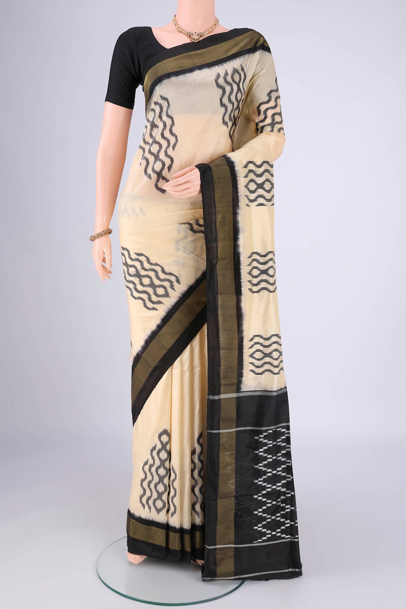 Cream Pochampally Silk Saree with Ikat design on the body and Plain Border.  displayed on a mannequin