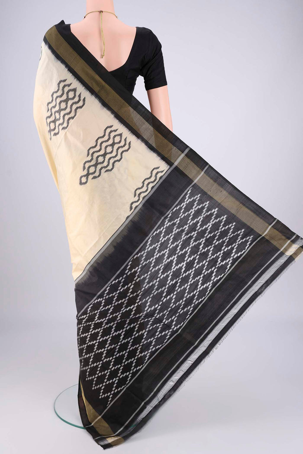 Flat view of Cream Pochampally Silk Saree with Ikat design on the body and Plain Border. 