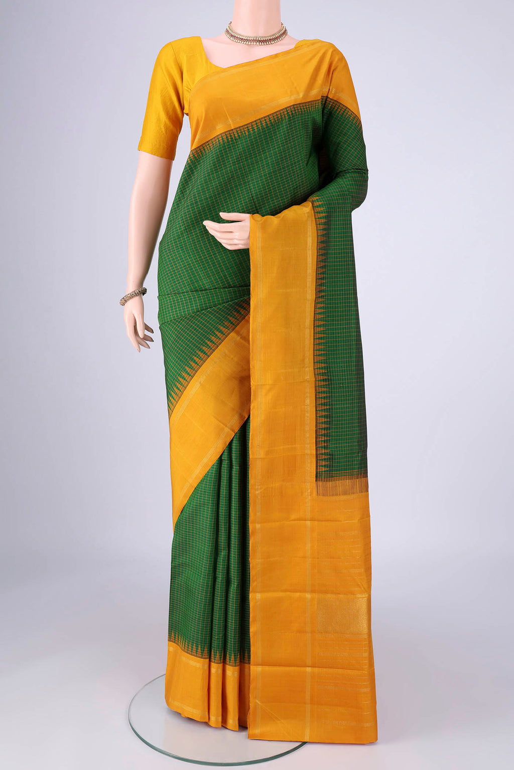 Green Kanchipuram Silk Saree with Checked design on the body and Zari Border.  displayed on a mannequin