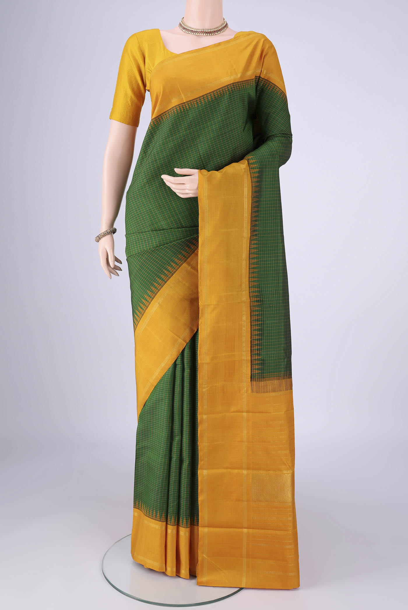 Green Kanchipuram Silk Saree with Checked design on the body and Zari Border.  displayed on a mannequin