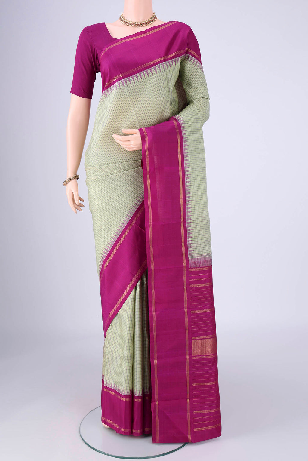 Pista Green Kanchipuram Silk Saree with Checked design on the body and Plain Border.  displayed on a mannequin