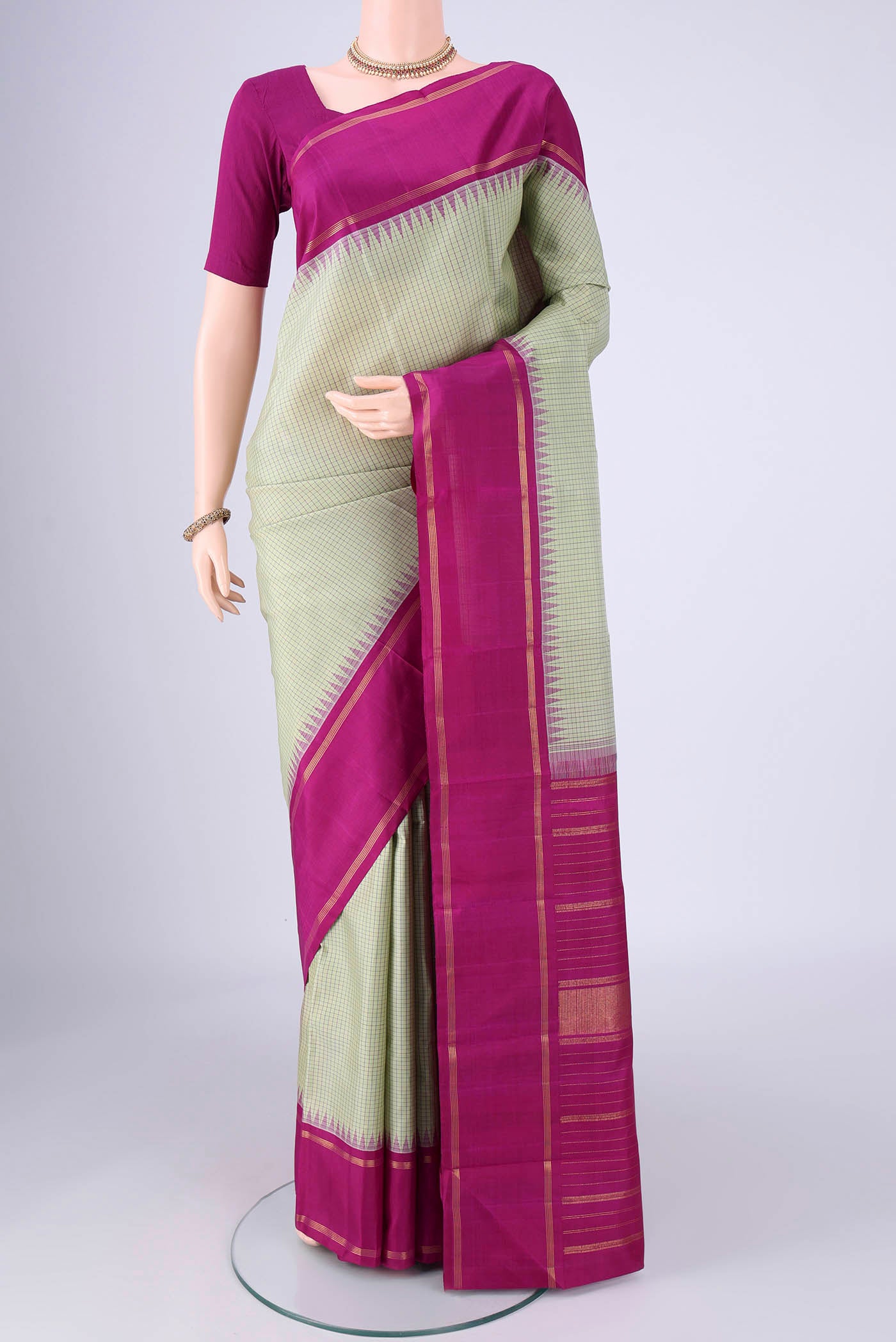 Pista Green Kanchipuram Silk Saree with Checked design on the body and Plain Border.  displayed on a mannequin