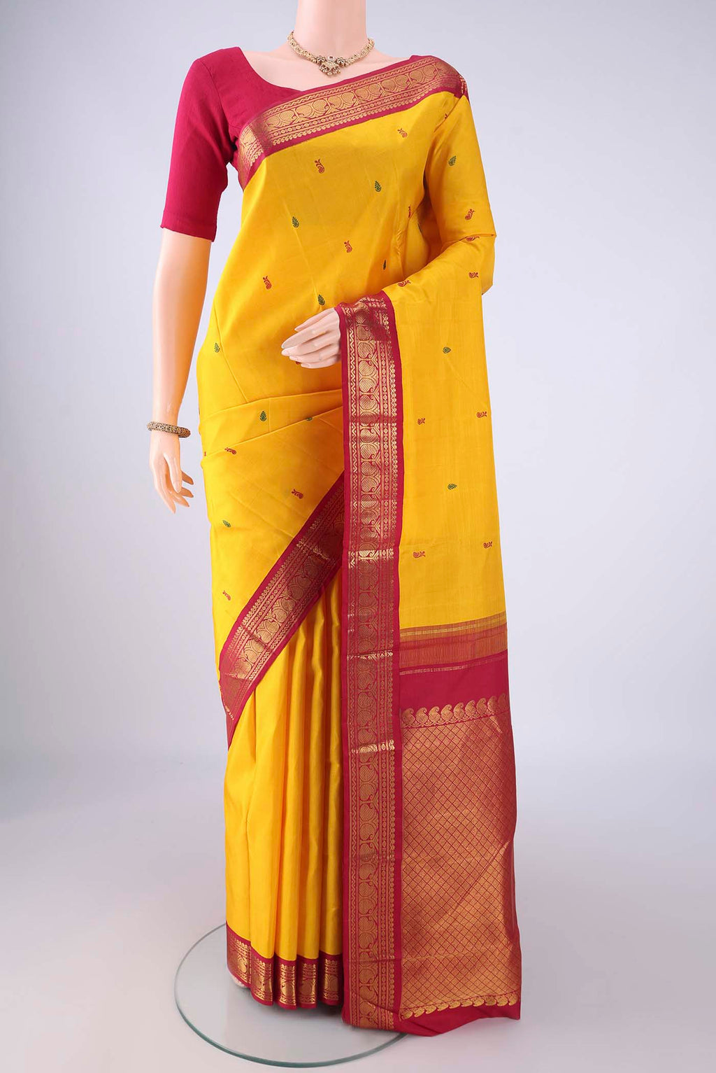 Yellow Kanjivaram Silk Saree with Thread Butta on the body and Zari Border.  displayed on a mannequin