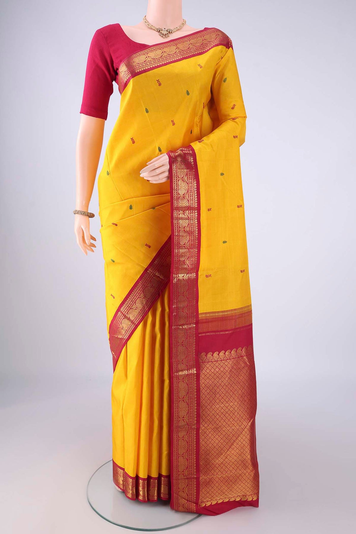 Yellow Kanjivaram Silk Saree with Thread Butta on the body and Zari Border.  displayed on a mannequin