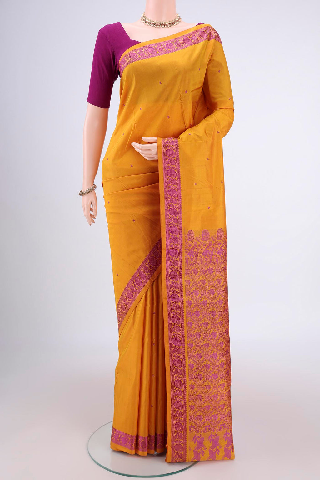 Mustard Kanchipuram Silk Saree with Thread Butta on the body and Thread Border.  displayed on a mannequin