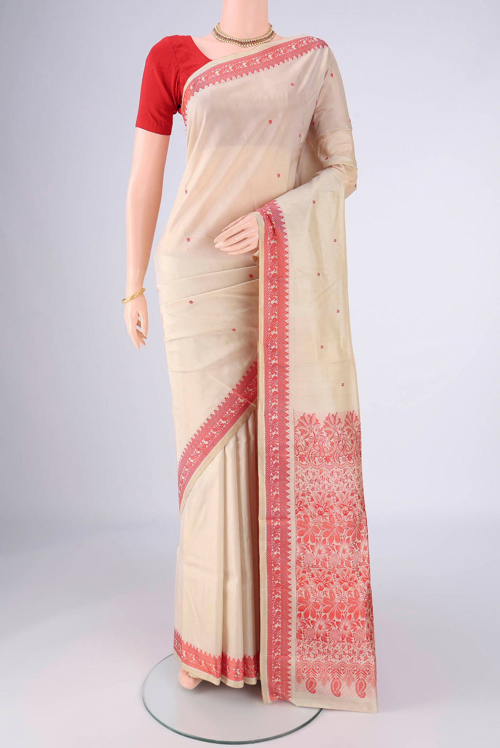Beige Kanchipuram Silk Saree with Thread Butta on the body and Thread Border.  displayed on a mannequin