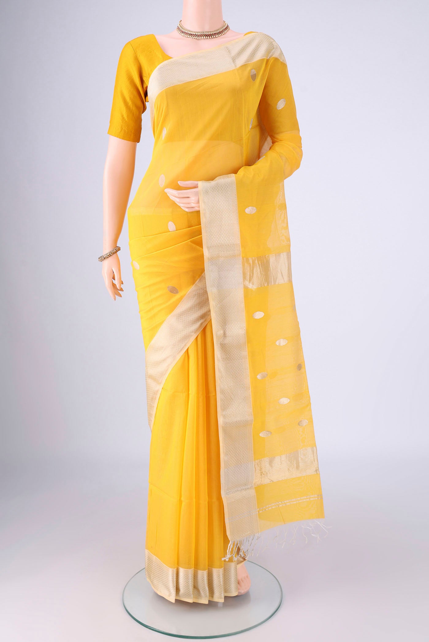 Yellow Maheshwari Silk Cotton Saree with Zari Butta on the body and Zari Border.  displayed on a mannequin
