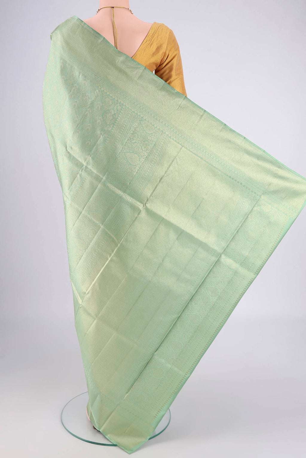 Flat view of Mint Green Soft Silk Saree with Zari Butta on the body and Zari Border. 