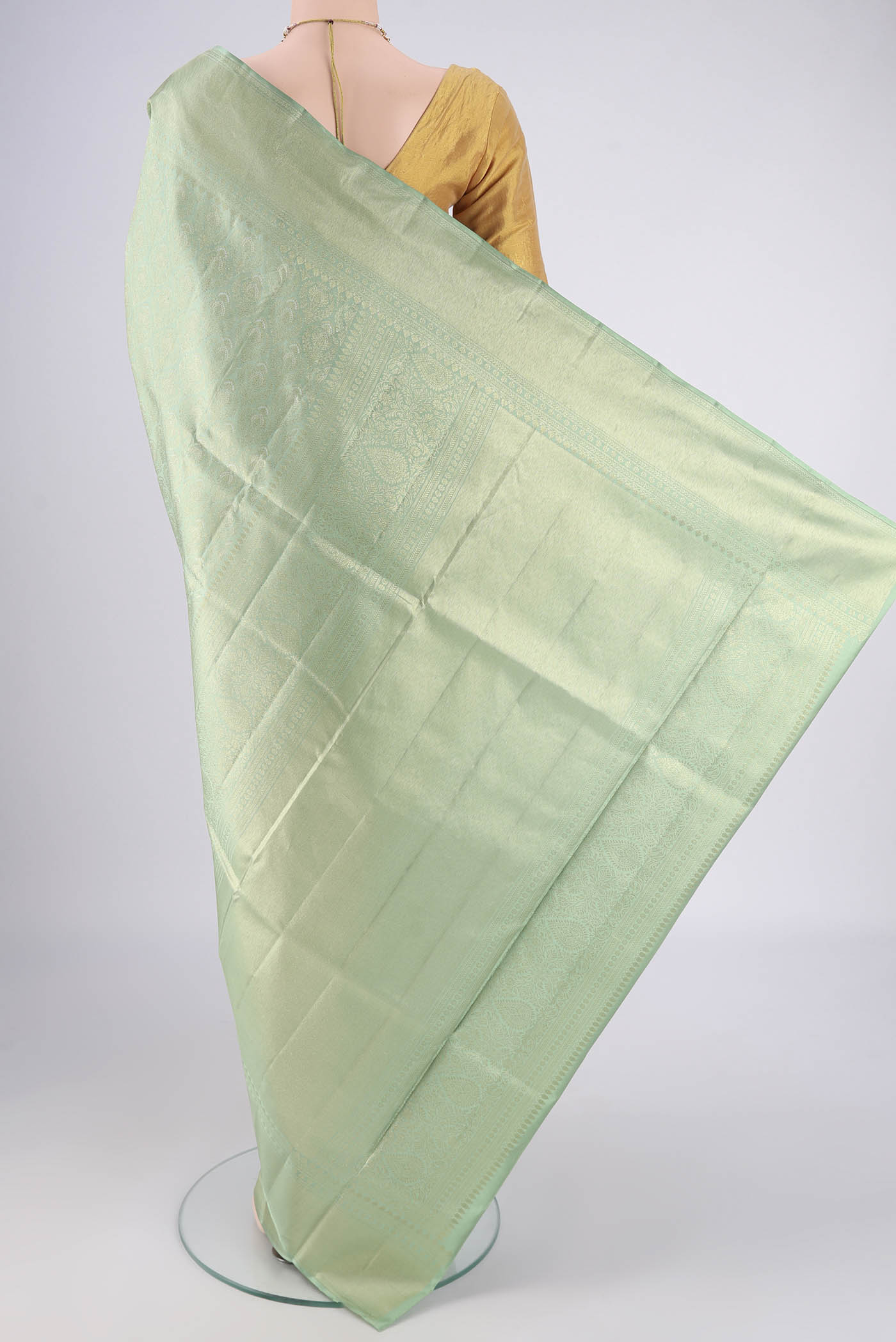 Flat view of Mint Green Soft Silk Saree with Zari Butta on the body and Zari Border. 