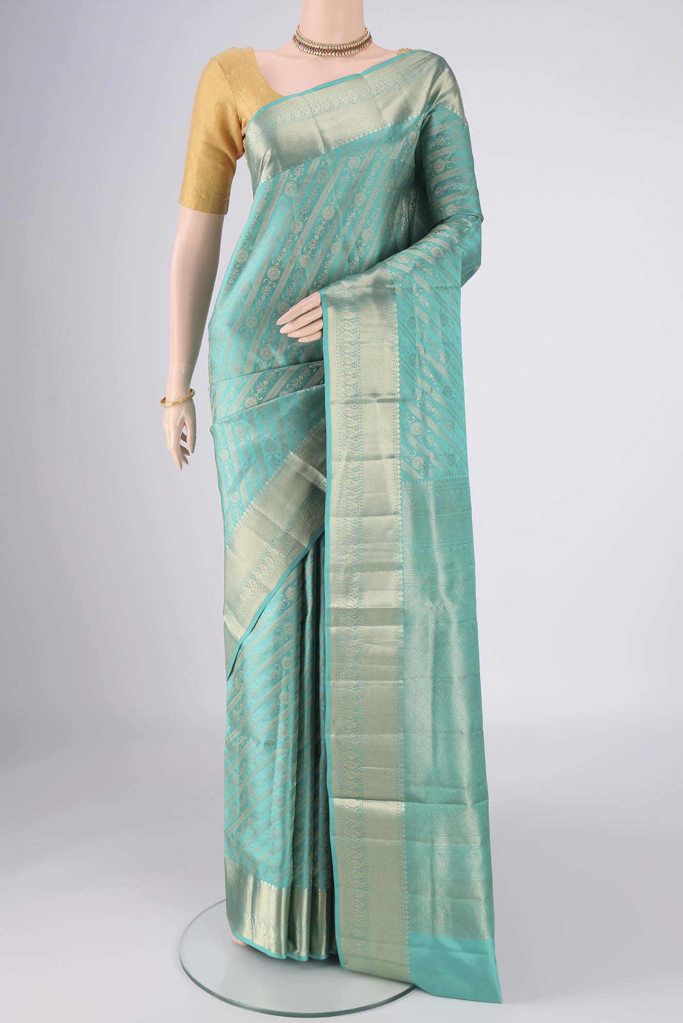 Turquoise Soft Silk Saree with Zari Brocade on the body and Zari Border.  displayed on a mannequin