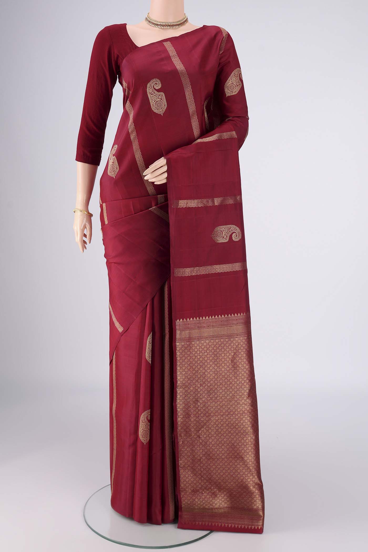 Maroon Soft Silk Saree with Zari Butta on the body and Without Border.  displayed on a mannequin