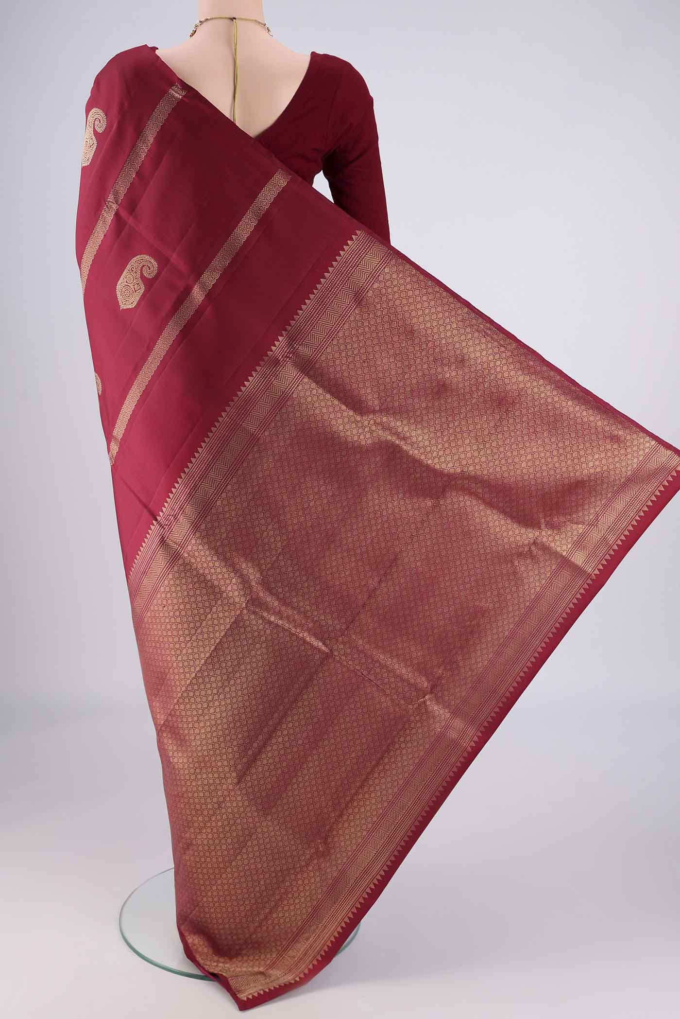 Flat view of Maroon Soft Silk Saree with Zari Butta on the body and Without Border. 
