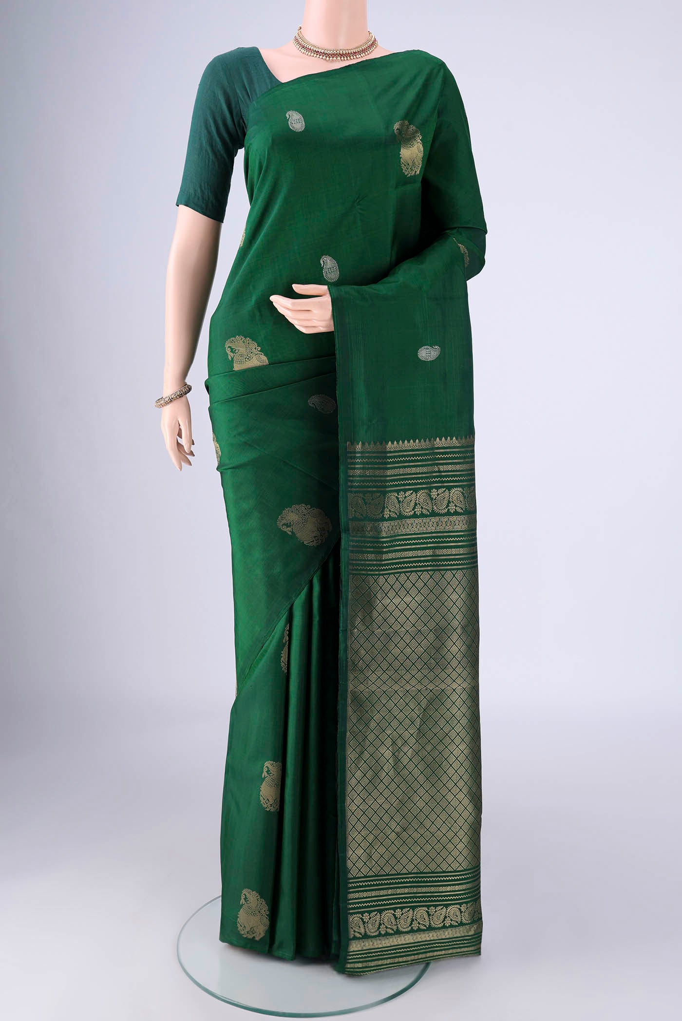 Bottle Green Soft Silk Saree with Zari Butta on the body and Plain Border.  displayed on a mannequin