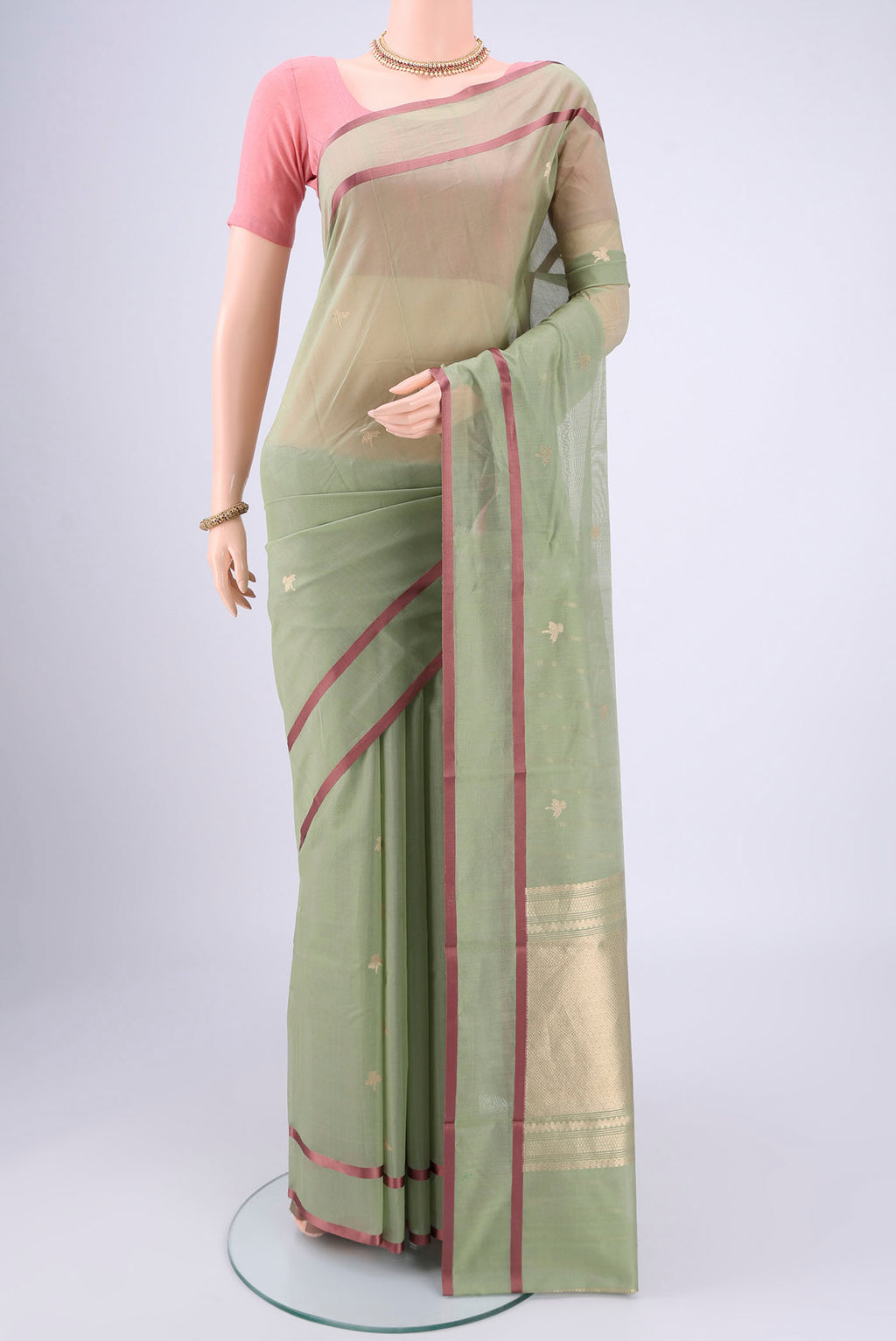 Sage Green Chanderi Silk Cotton Saree with Zari Butta on the body and Thread Border.  displayed on a mannequin