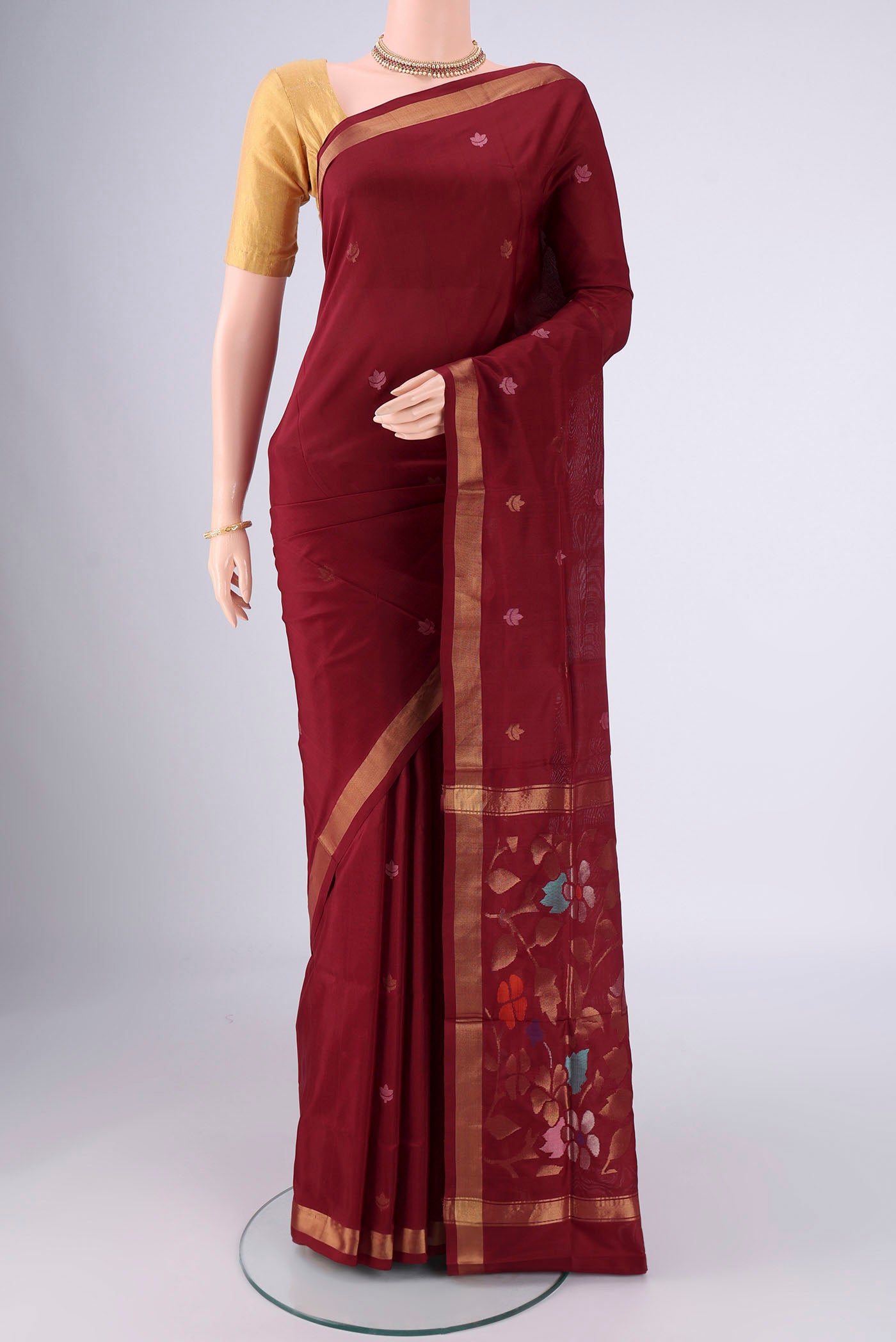Maroon Uppada Silk Saree with Zari And Thread Butta on the body and Zari Border.  displayed on a mannequin