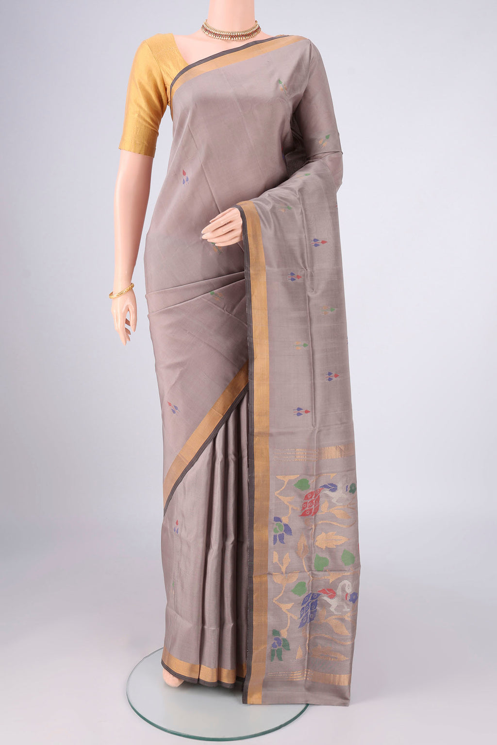 Grey Uppada Silk Saree with Zari And Thread Butta on the body and Zari Border.  displayed on a mannequin