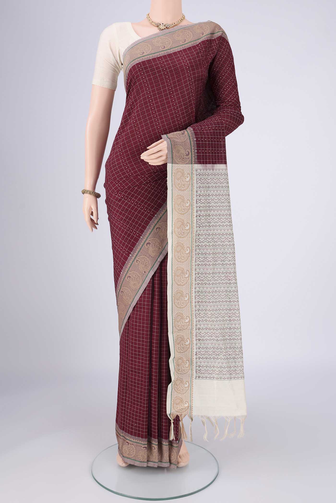 Maroon Blended Poly Cotton Saree with Checked design on the body and Thread Border.  displayed on a mannequin