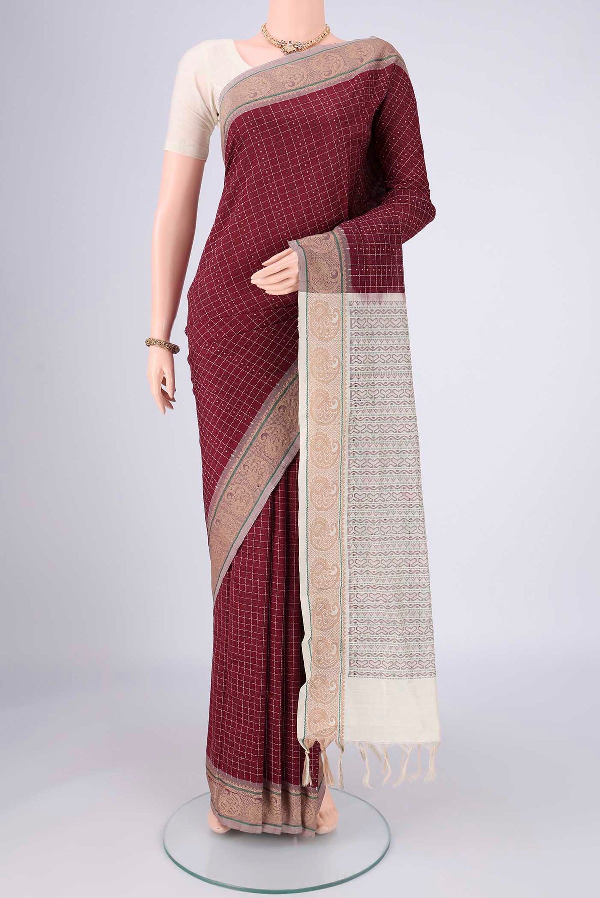 Maroon Blended Poly Cotton Saree with Checked design on the body and Thread Border.  displayed on a mannequin