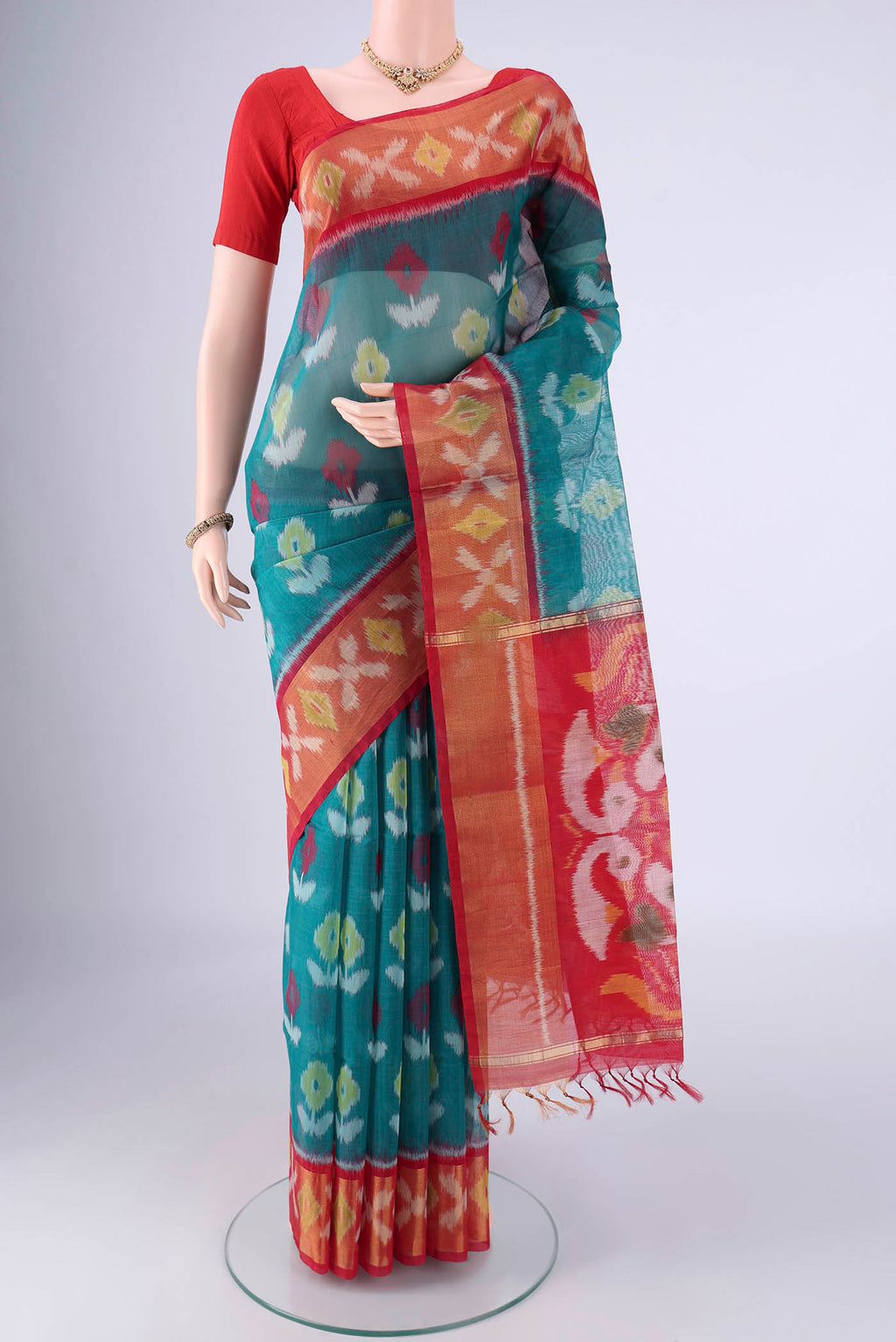 Teal Silk Cotton Saree with Ikat design on the body and Zari Border.  displayed on a mannequin