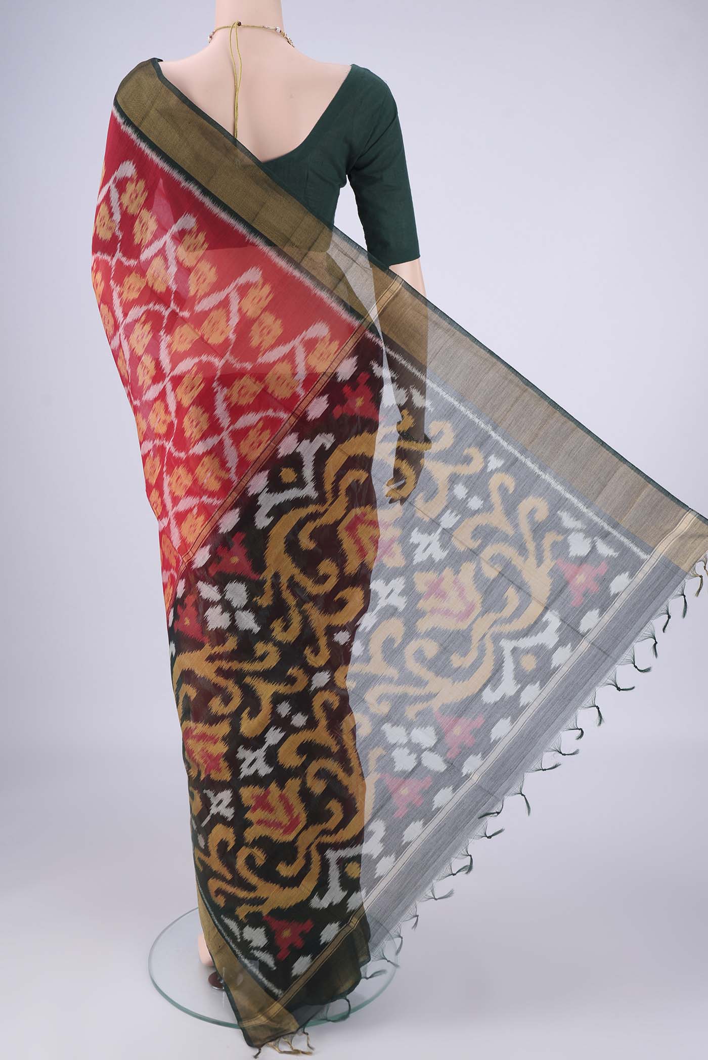 Flat view of Red Silk Cotton Saree with Ikat design on the body and Zari Border. 