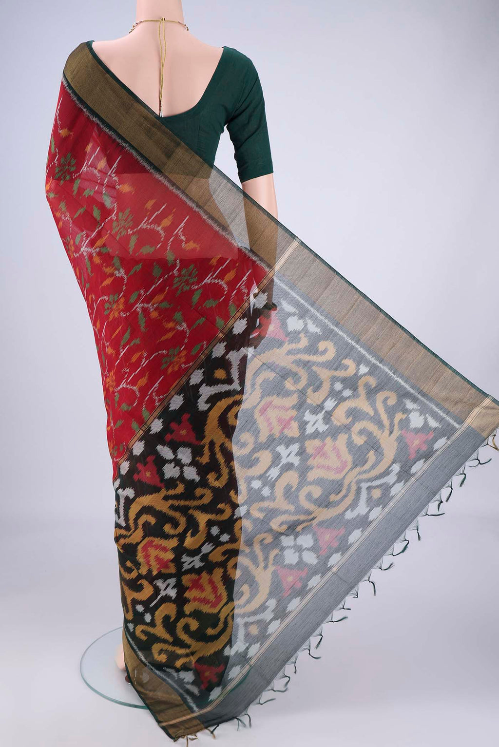 Flat view of Maroon Silk Cotton Saree with Ikat design on the body and Zari Border. 