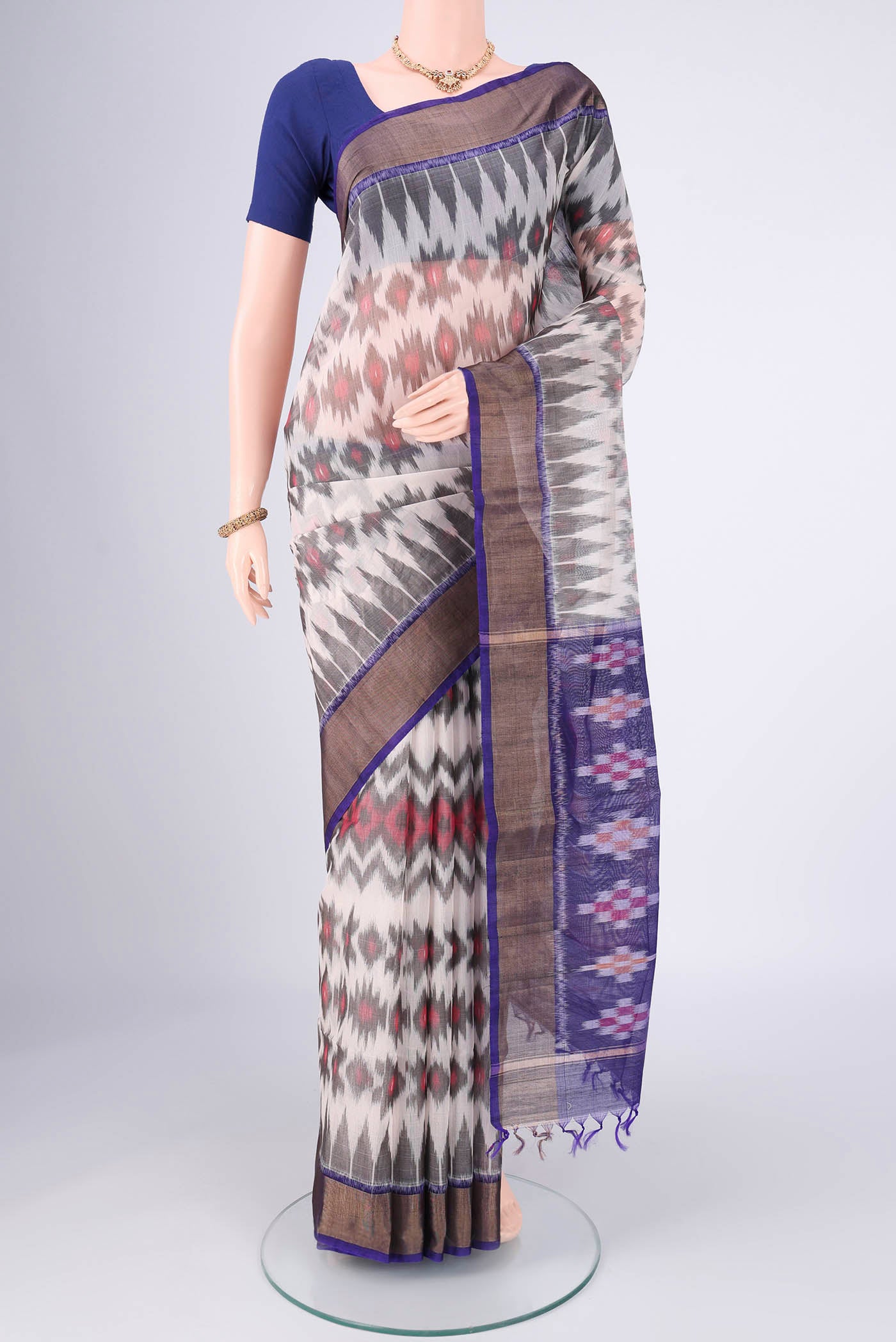 Off White Kora Cotton Saree with Ikat design on the body and Zari Border.  displayed on a mannequin