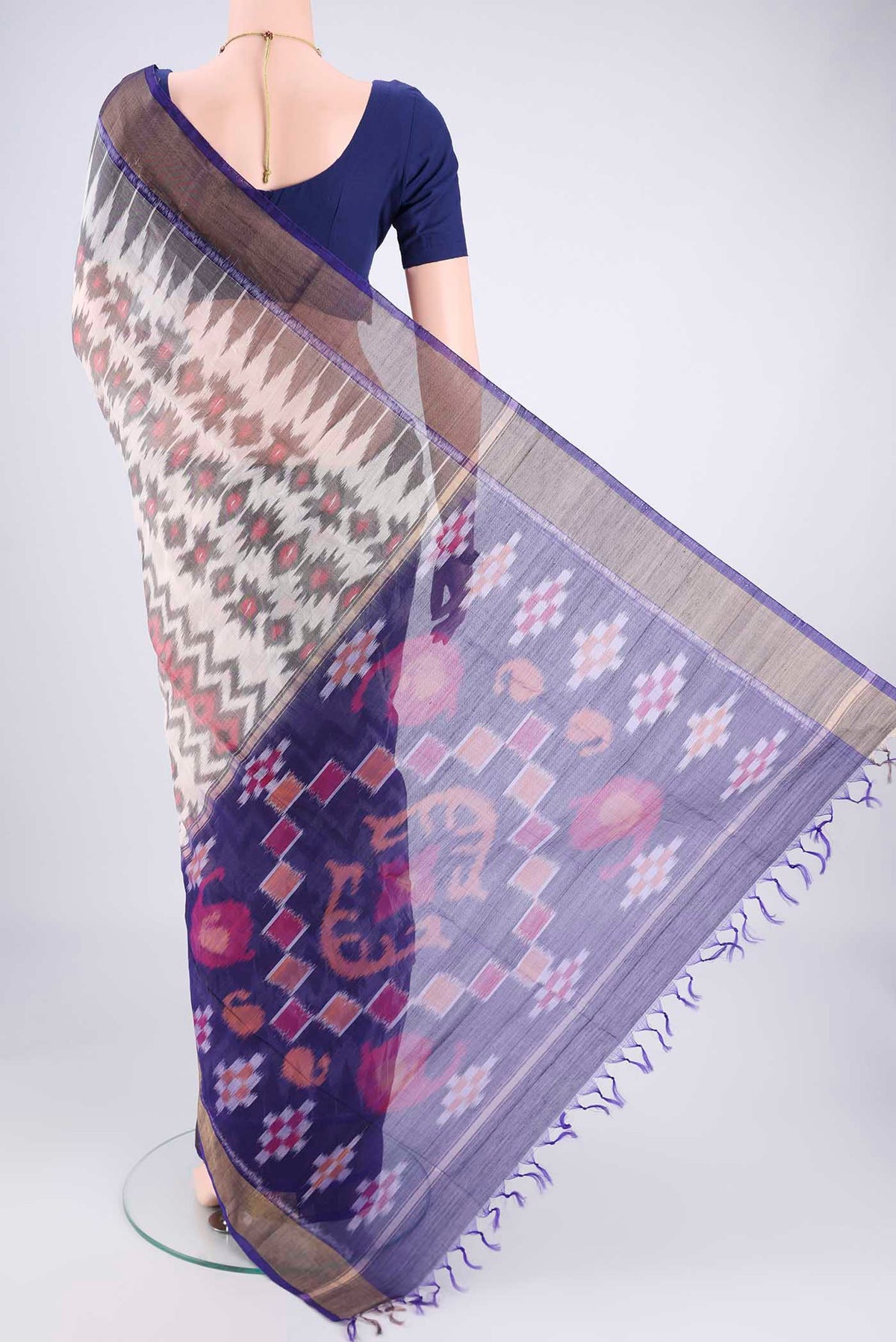 Flat view of Off White Kora Cotton Saree with Ikat design on the body and Zari Border. 