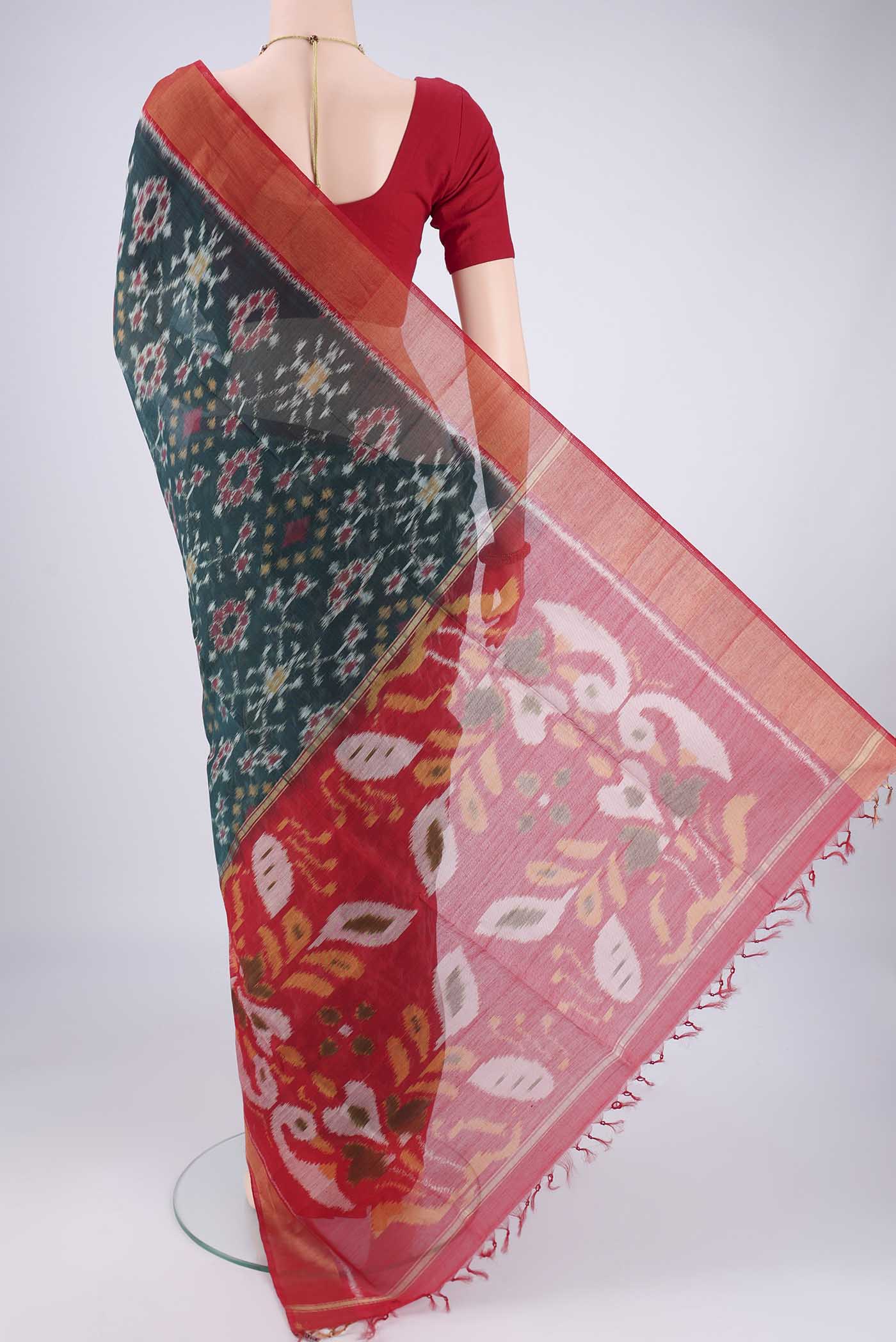Flat view of Bottle Green Kora Cotton Saree with Ikat design on the body and Zari Border. 
