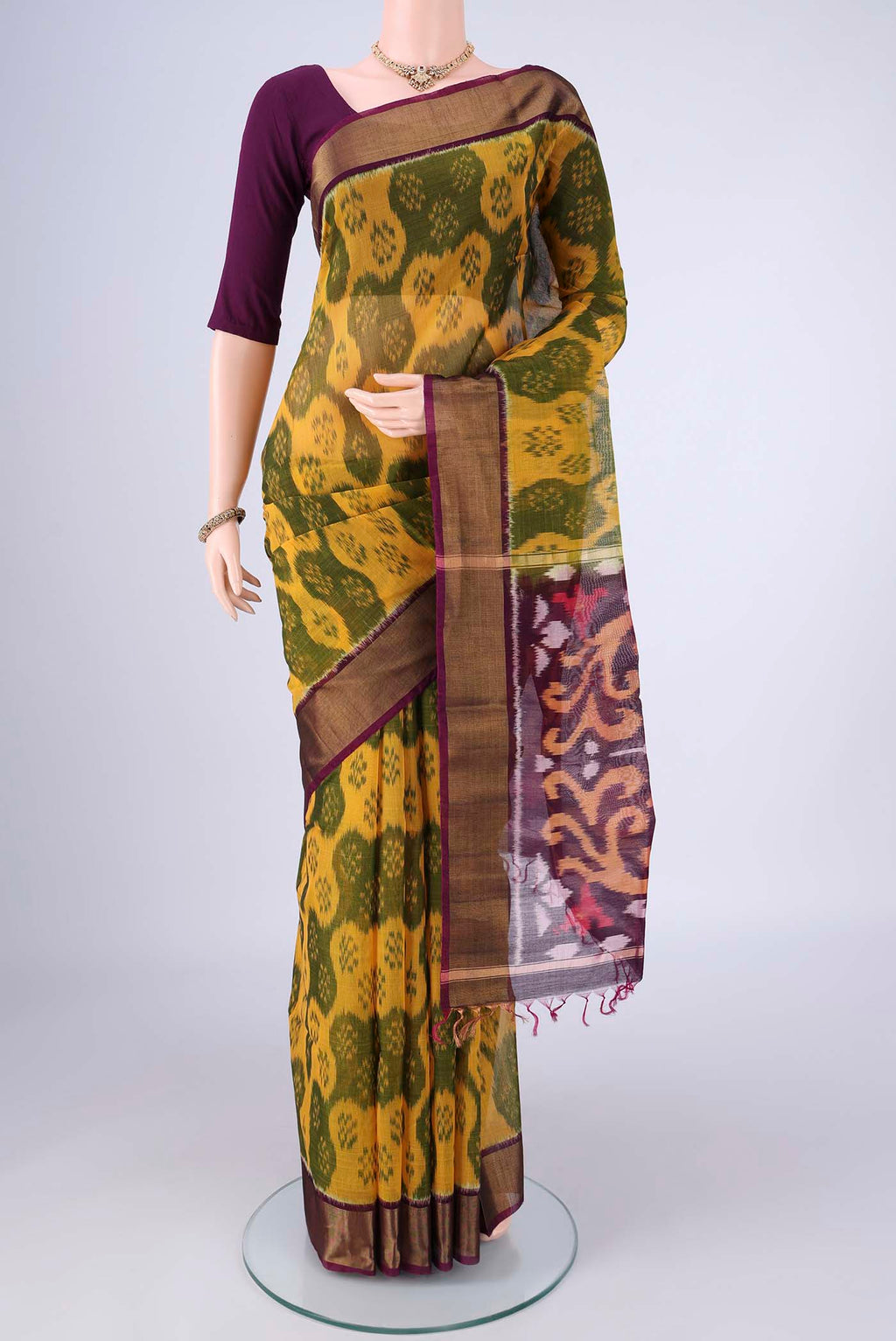 Yellow Silk Cotton Saree with Ikat design on the body and Zari Border.  displayed on a mannequin