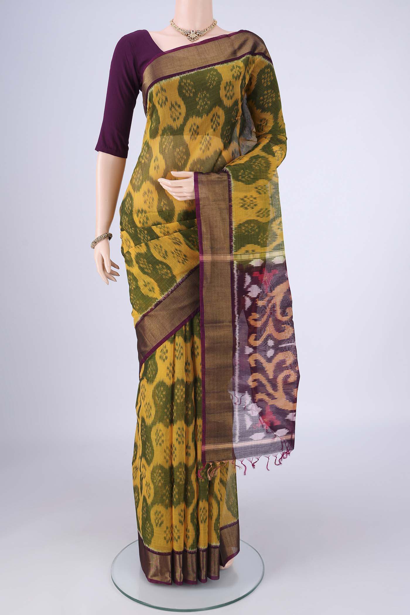 Yellow Silk Cotton Saree with Ikat design on the body and Zari Border.  displayed on a mannequin