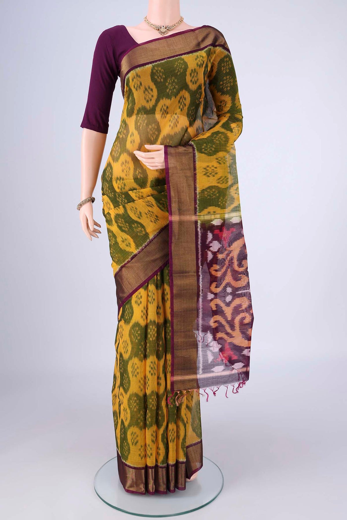 Yellow Silk Cotton Saree with Ikat design on the body and Zari Border.  displayed on a mannequin