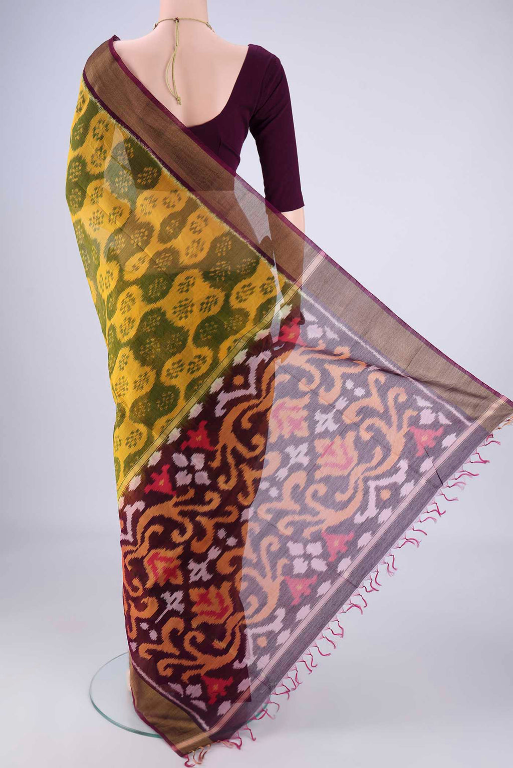 Flat view of Yellow Silk Cotton Saree with Ikat design on the body and Zari Border. 