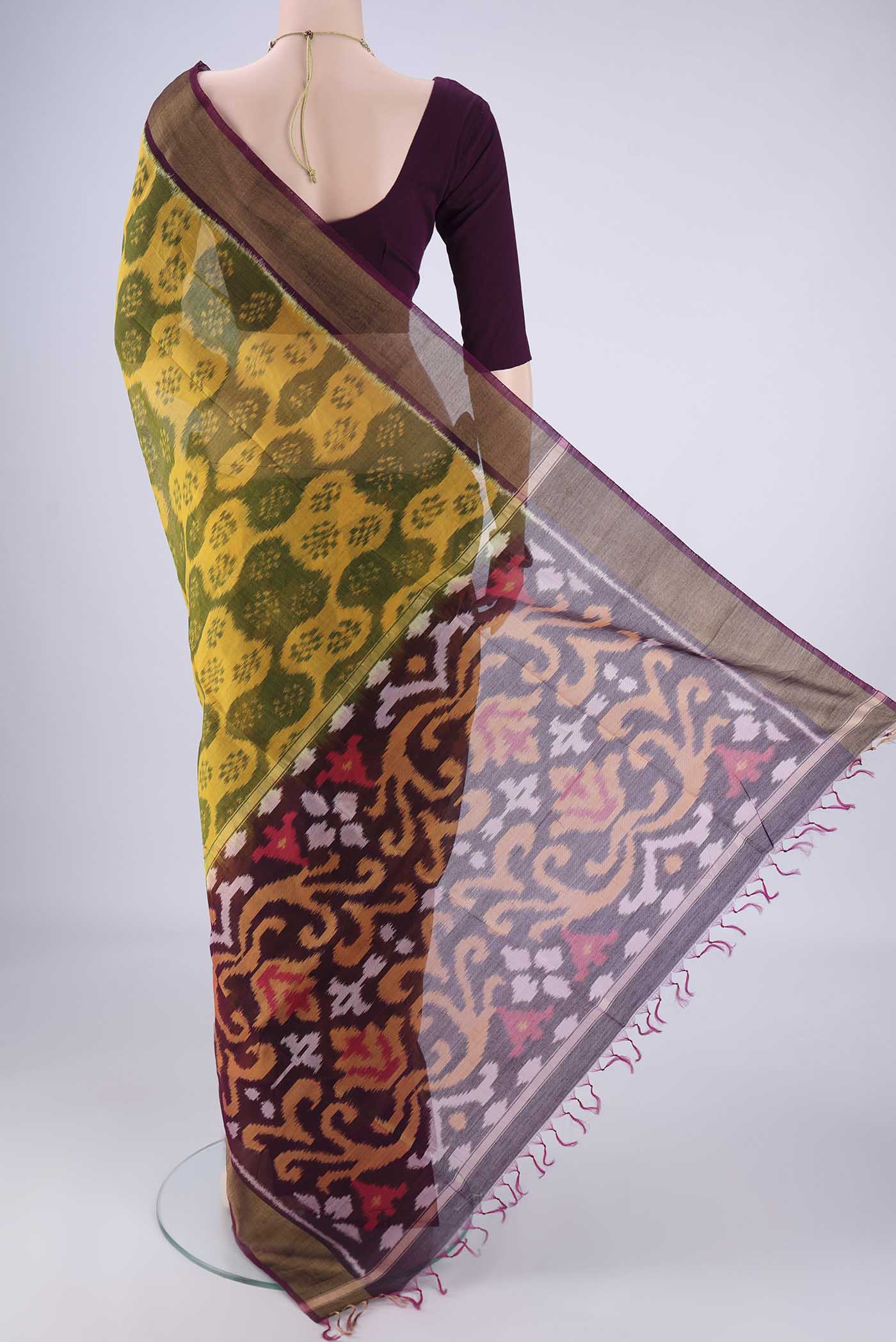 Flat view of Yellow Silk Cotton Saree with Ikat design on the body and Zari Border. 