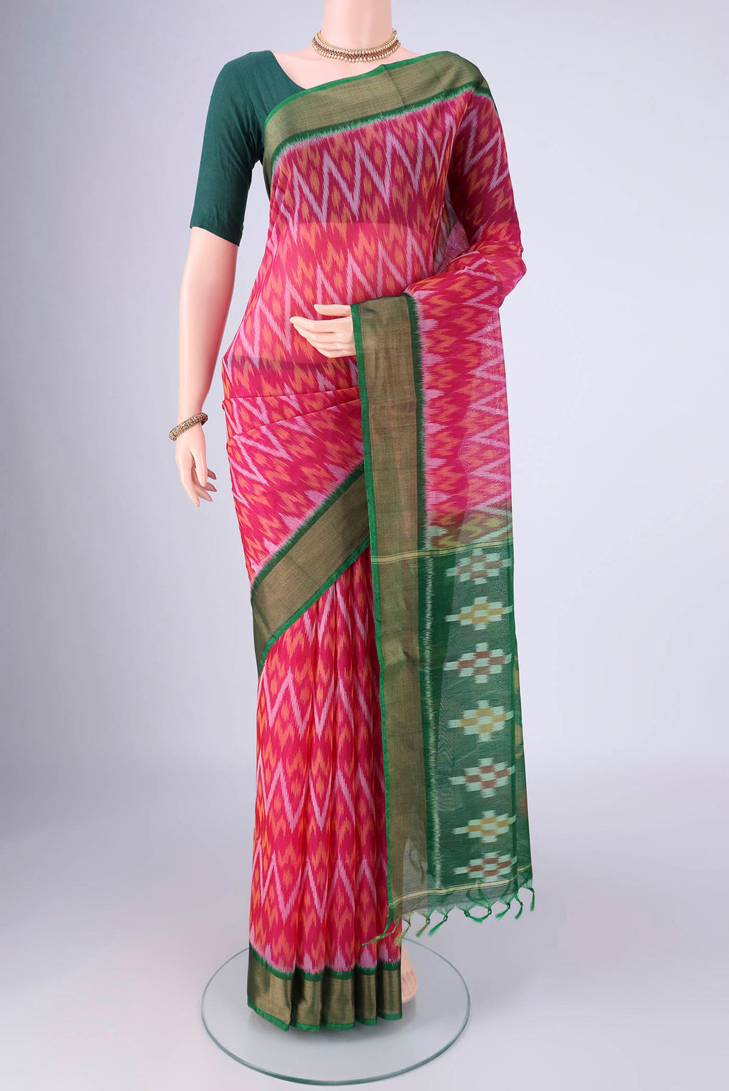 Rani Pink Silk Cotton Saree with Ikat design on the body and Zari Border.  displayed on a mannequin