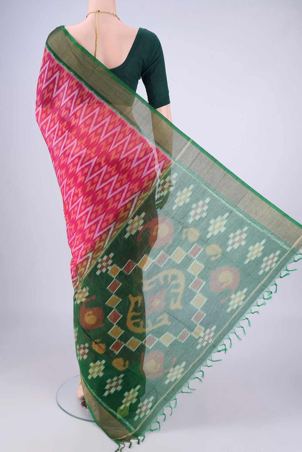 Flat view of Rani Pink Silk Cotton Saree with Ikat design on the body and Zari Border. 