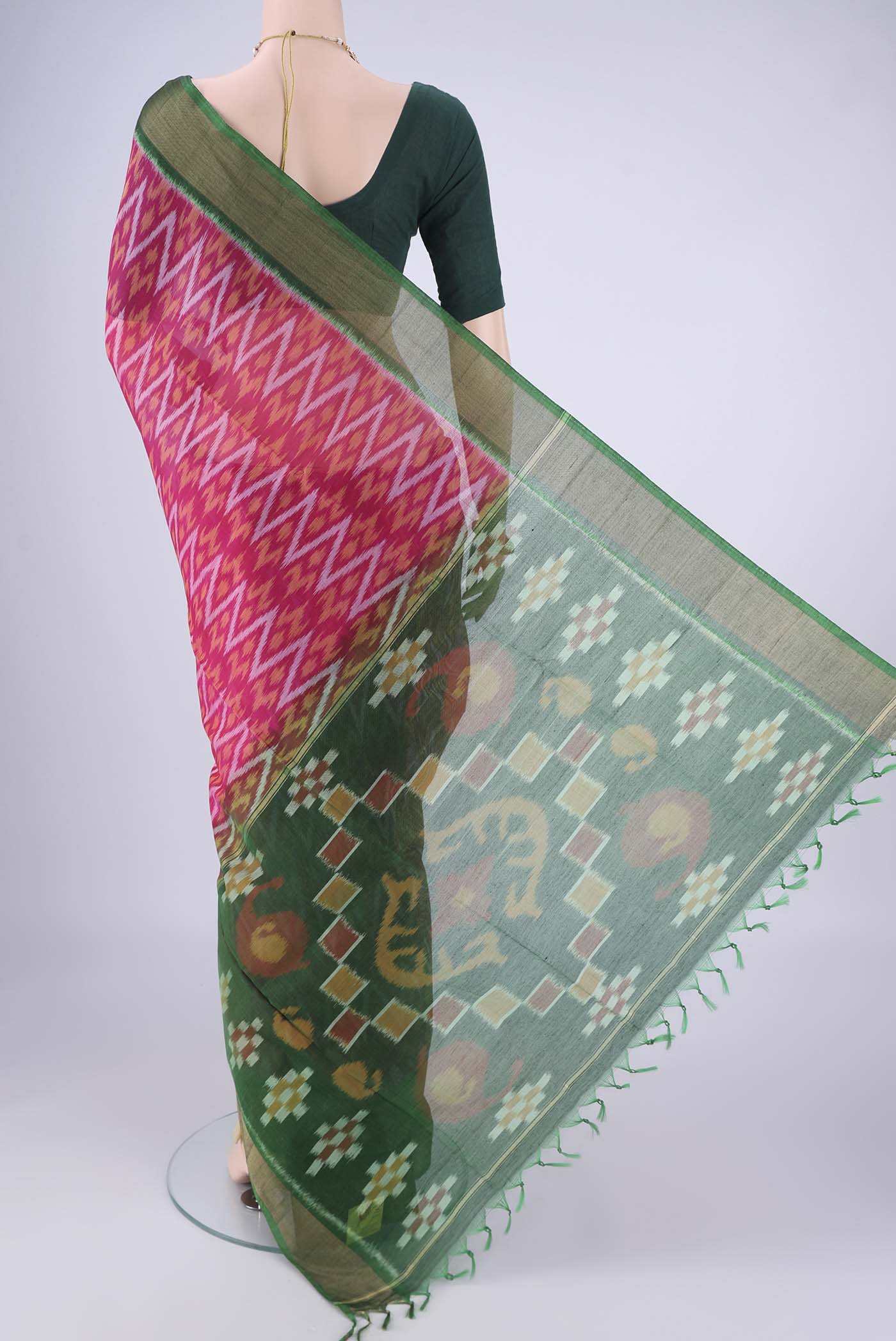 Flat view of Rani Pink Silk Cotton Saree with Ikat design on the body and Zari Border. 