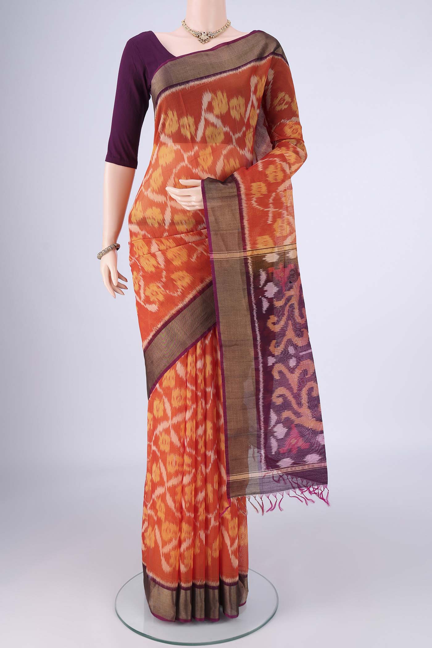 Brick Orange Silk Cotton Saree with Ikat design on the body and Zari Border.  displayed on a mannequin