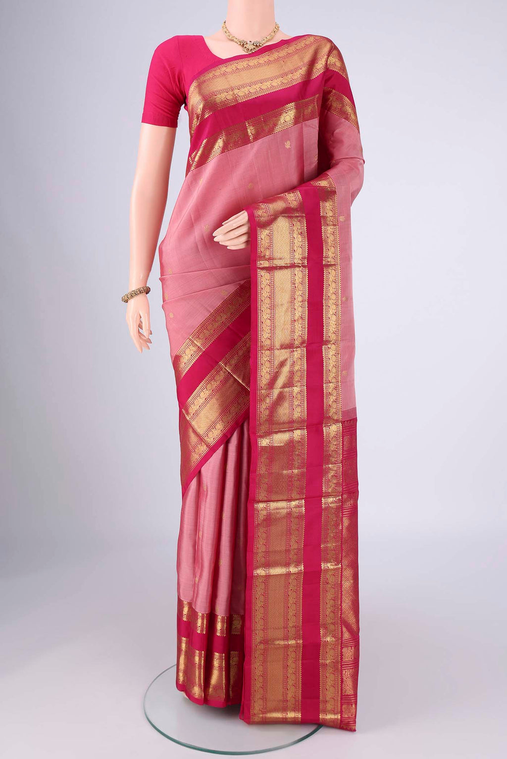 Rose Gold Kanchipuram Silk Saree with Zari Butta on the body and Zari Border.  displayed on a mannequin