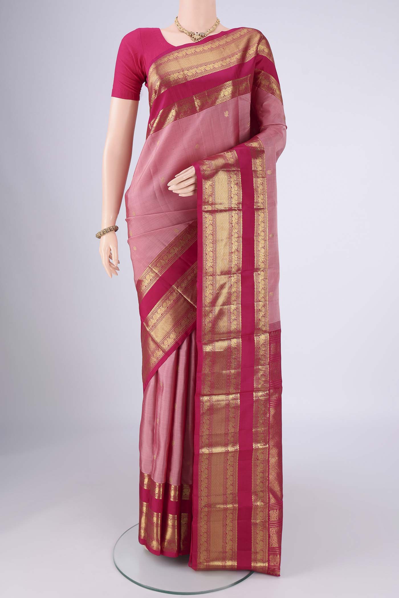 Rose Gold Kanchipuram Silk Saree with Zari Butta on the body and Zari Border.  displayed on a mannequin